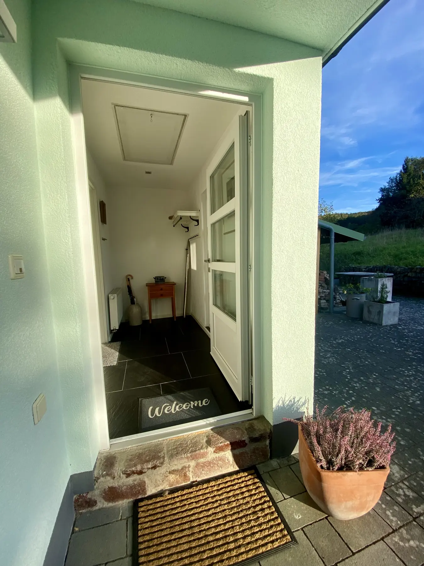 Die offene Haustür des Ferienhauses mit Blick in den Flur