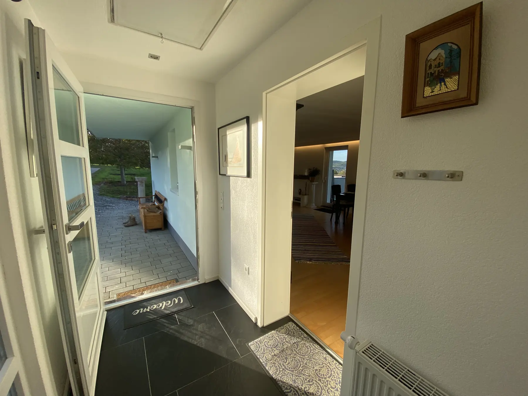 Blick durch den Flur ins Wohnzimmer und hinaus auf den Hof